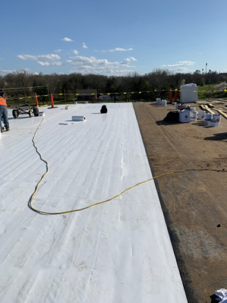 commercial roofers working on a flat roof replacement.