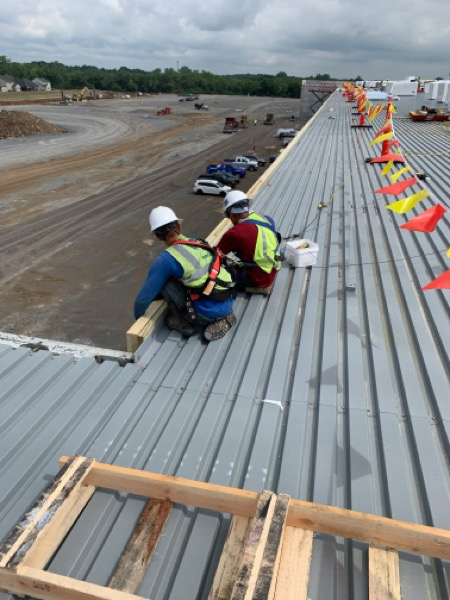 roofers working on a commercial metal roof 