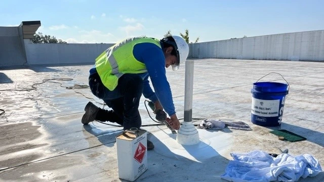 Crew member sealing around a roof vent